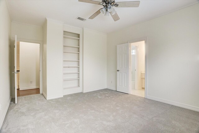 unfurnished bedroom with crown molding, a closet, baseboards, carpet flooring, and visible vents