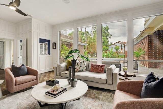 living room with wood finished floors, a decorative wall, and ceiling fan