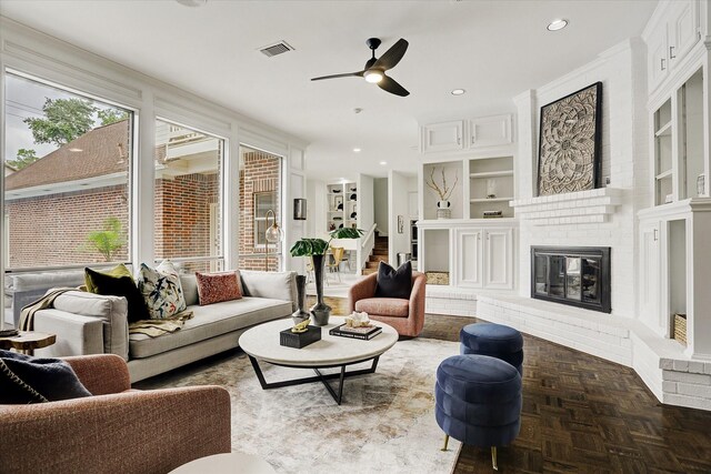 living area with built in shelves, ceiling fan, a fireplace, visible vents, and recessed lighting