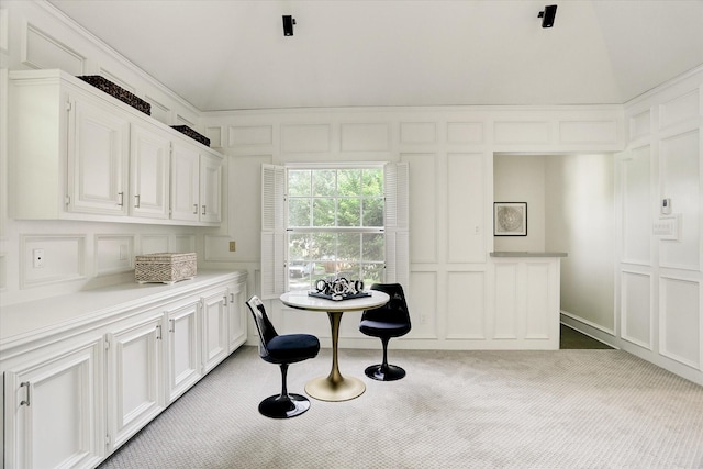 dining area with light colored carpet and a decorative wall