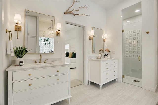 bathroom featuring two vanities, a sink, and a stall shower
