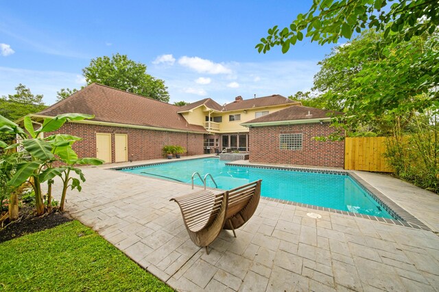 outdoor pool with a patio and fence