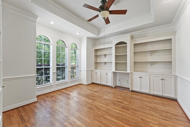 23056 Volga Dr, Porter, TX 77365 - interior space featuring a ceiling fan, crown molding, a tray ceiling, and light wood finished floors