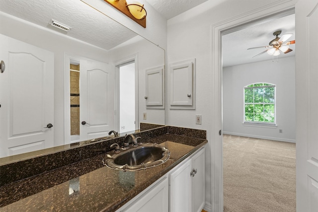 23056 Volga Dr, Porter, TX 77365 - bathroom with a ceiling fan, a textured ceiling, vanity, baseboards, and visible vents