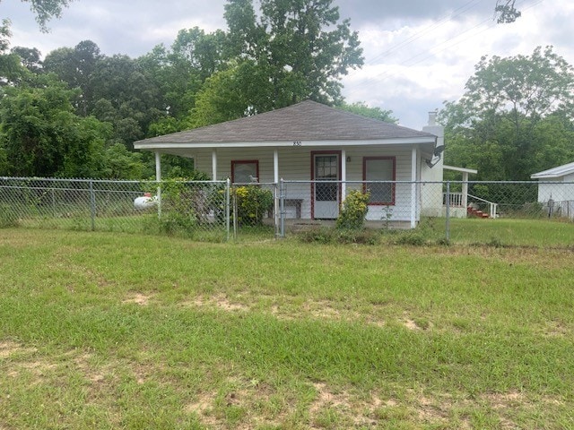 bungalow-style home featuring covered porch, fence private yard, a chimney, and a front yard