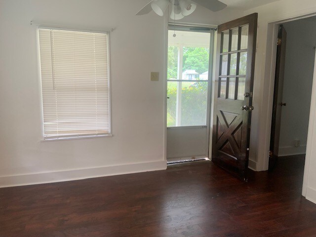 entryway featuring a ceiling fan, baseboards, and dark wood-style floors