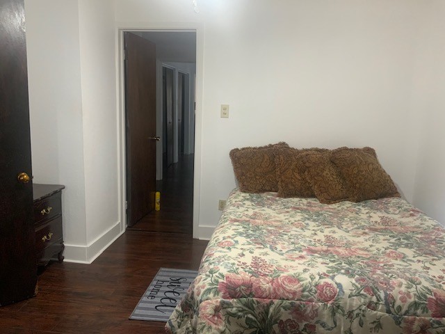 bedroom featuring baseboards and dark wood-style floors