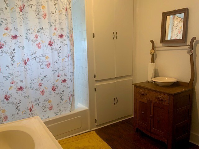 bathroom featuring shower / tub combo, vanity, and wood finished floors