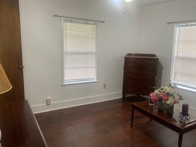 interior space featuring baseboards and dark wood-style floors
