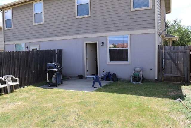 back of house featuring a yard, a patio area, and a fenced backyard