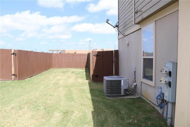 view of yard with central AC and a fenced backyard