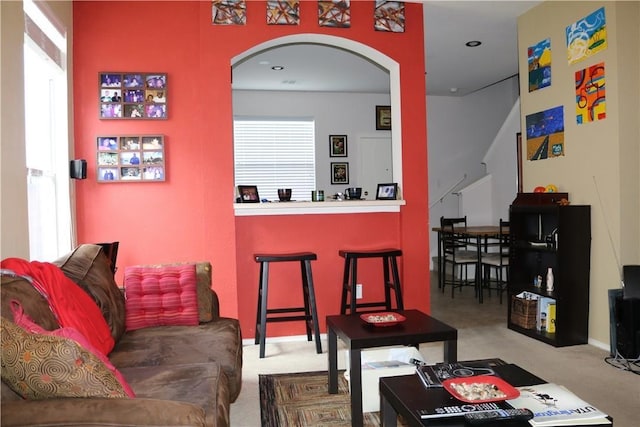 carpeted living room with baseboards, arched walkways, and recessed lighting