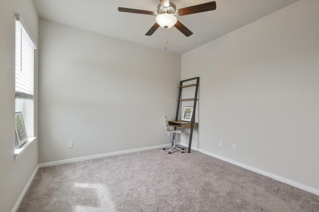 spare room with carpet floors, a ceiling fan, and baseboards