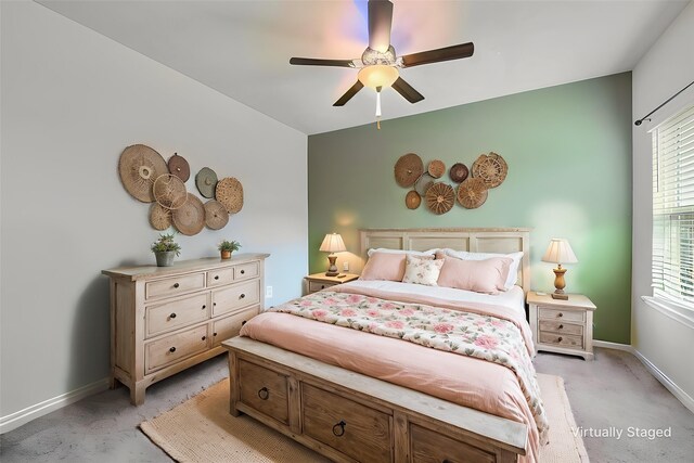 bedroom with light colored carpet, ceiling fan, and baseboards
