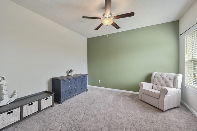sitting room with a wealth of natural light, a ceiling fan, baseboards, and light carpet