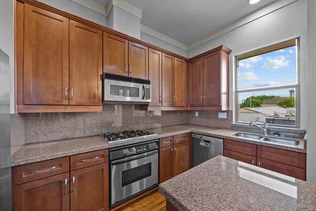 5212 Lillian St, Houston, TX 77007 - kitchen featuring appliances with stainless steel finishes, a sink, decorative backsplash, and light wood finished floors