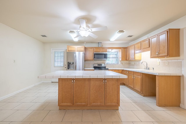 5003 Lord Rd, Crosby, TX 77532 - kitchen featuring tile counters, a sink, stainless steel appliances, backsplash, and baseboards