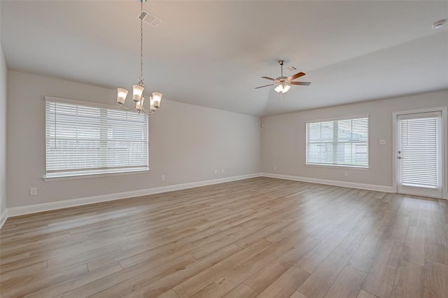 unfurnished room with baseboards, light wood-style floors, visible vents, and ceiling fan with notable chandelier