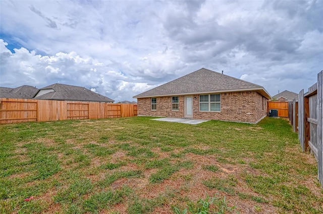 rear view of property with brick siding, a patio area, a lawn, and a fenced backyard