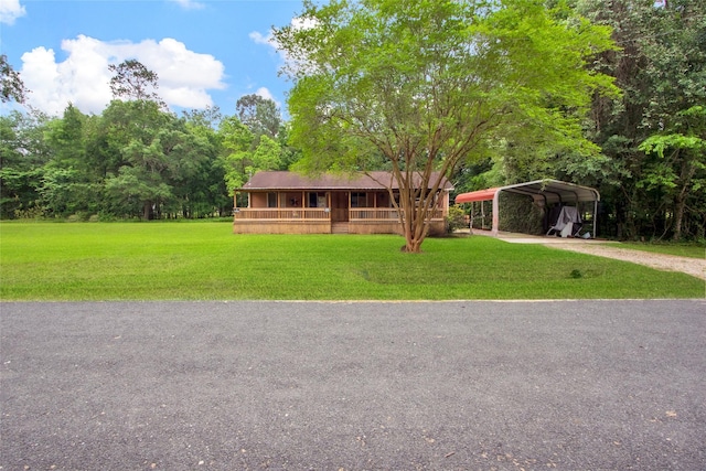 view of front facade with driveway, a carport, a porch, and a front yard