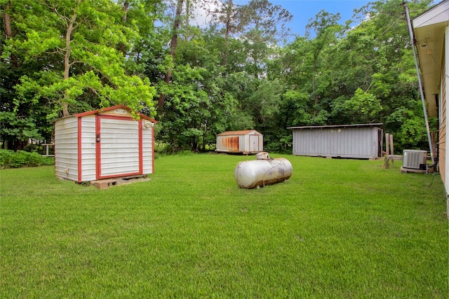 view of yard with an outdoor structure, cooling unit, and a shed