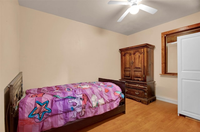 bedroom featuring baseboards, a ceiling fan, and light wood-style floors