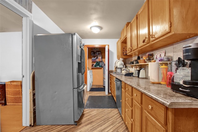 kitchen with a sink, stainless steel appliances, and light wood-type flooring