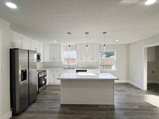 5814 W Bellfort Ave, Houston, TX 77035 - kitchen with a center island, a sink, baseboards, backsplash, and appliances with stainless steel finishes