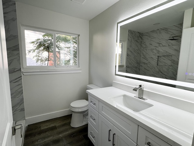 5814 W Bellfort Ave, Houston, TX 77035 - bathroom featuring tiled shower, toilet, visible vents, wood finished floors, and vanity