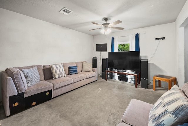 living area featuring unfinished concrete floors, a ceiling fan, and visible vents
