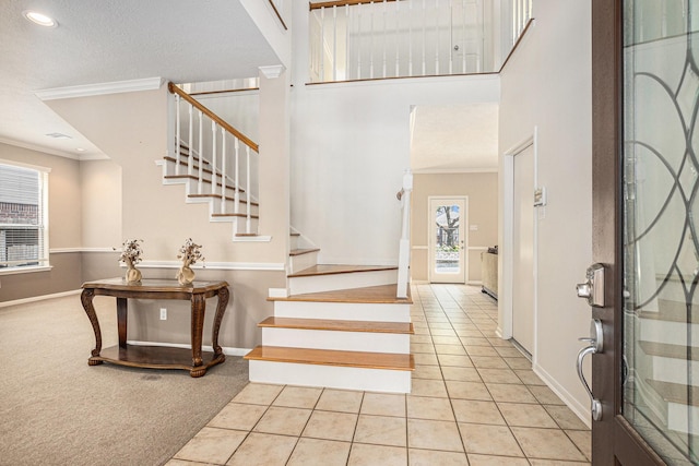 15242 Shapiro Springs Ln, Houston, TX 77095 - carpeted foyer with ornamental molding, baseboards, stairway, tile patterned floors, and a towering ceiling
