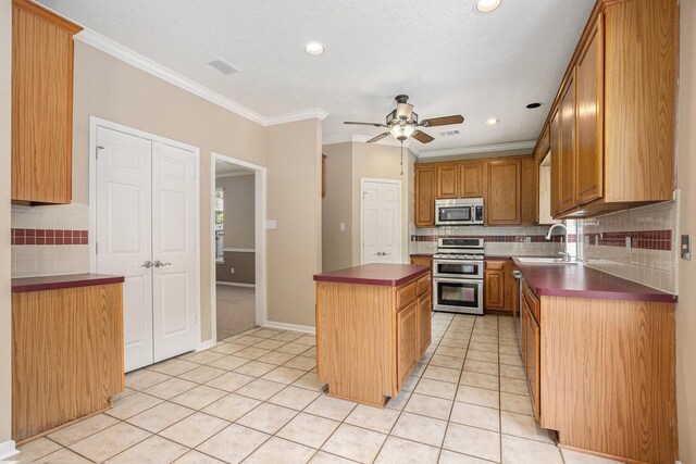 15242 Shapiro Springs Ln, Houston, TX 77095 - kitchen with stainless steel appliances, light tile patterned flooring, tasteful backsplash, a ceiling fan, and crown molding