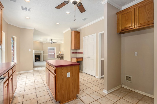 15242 Shapiro Springs Ln, Houston, TX 77095 - kitchen with a ceiling fan, a center island, open floor plan, light tile patterned flooring, and crown molding