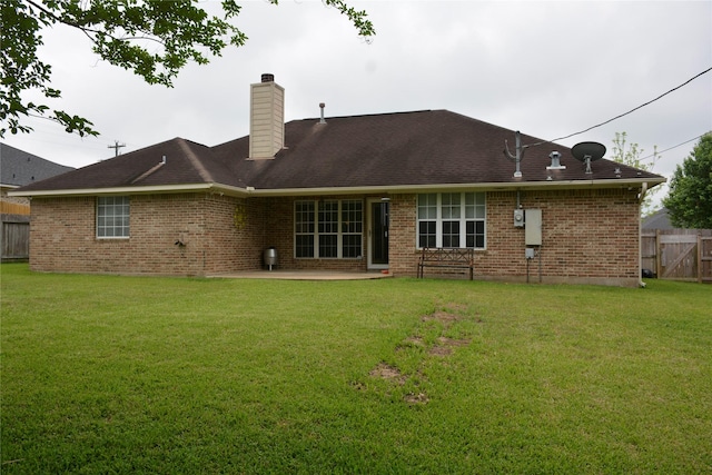 back of house with brick siding, a patio area, a chimney, and fence