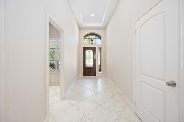 foyer featuring baseboards and light tile patterned flooring