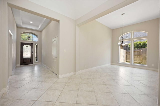 entryway with light tile patterned flooring, an inviting chandelier, and a wealth of natural light