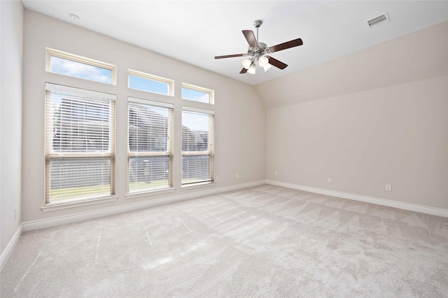 carpeted empty room featuring baseboards, a ceiling fan, and visible vents