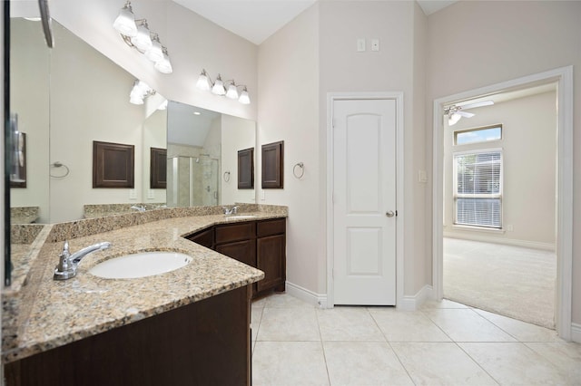 bathroom featuring vanity, baseboards, ceiling fan, and a stall shower