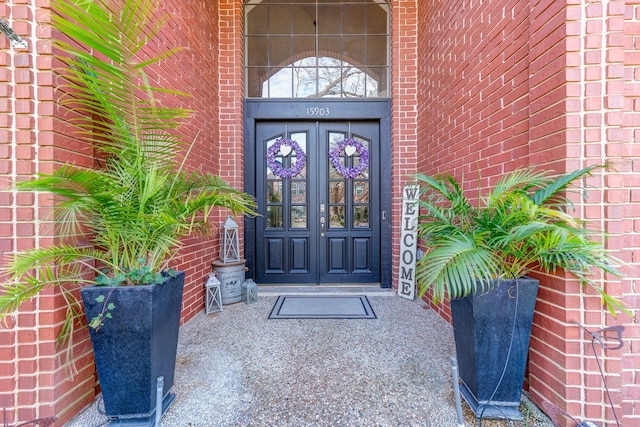 doorway to property featuring brick siding