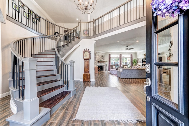 foyer featuring wood finished floors, crown molding, and stairway
