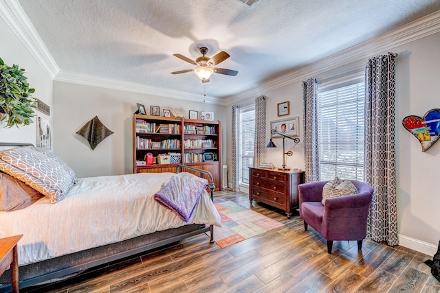 bedroom featuring crown molding, a ceiling fan, wood finished floors, a textured ceiling, and baseboards