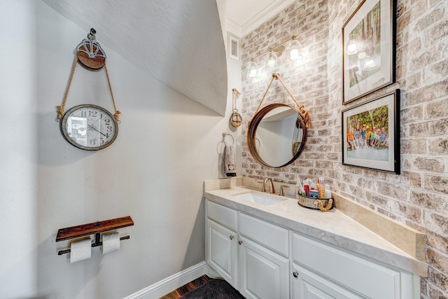 bathroom featuring baseboards, crown molding, vanity, and wood finished floors