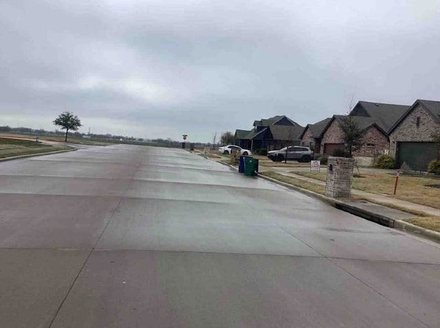 view of street with curbs, sidewalks, and a residential view