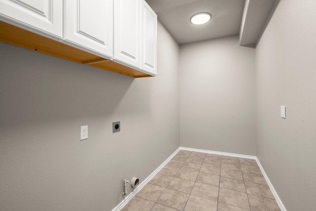 laundry room featuring cabinet space, baseboards, light tile patterned flooring, and hookup for an electric dryer