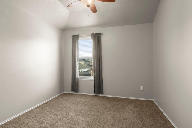 carpeted spare room with baseboards, a ceiling fan, and vaulted ceiling