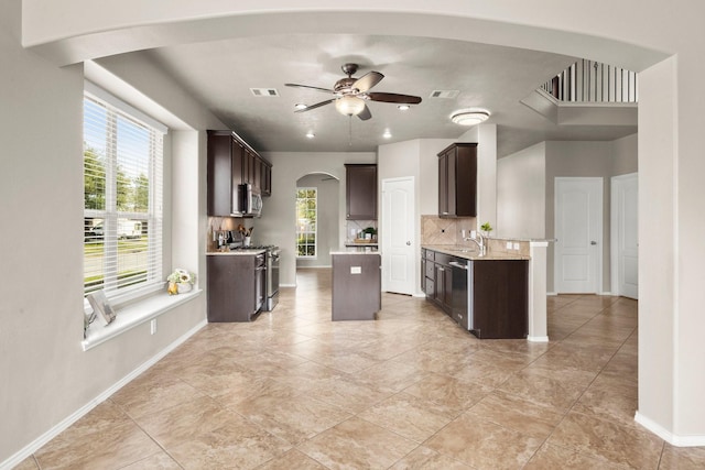 kitchen featuring dark brown cabinets, visible vents, arched walkways, appliances with stainless steel finishes, and ceiling fan