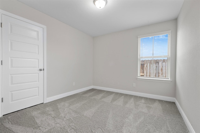 carpeted empty room with baseboards