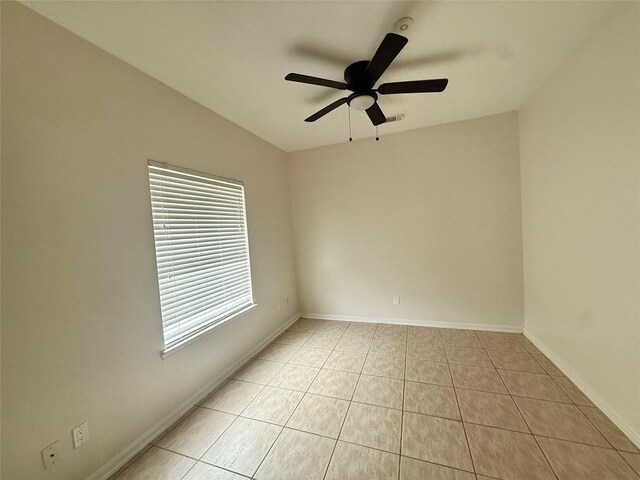 empty room featuring visible vents, baseboards, ceiling fan, and light tile patterned floors