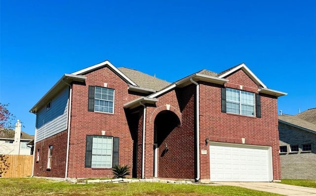 view of front facade with brick siding, an attached garage, fence, and driveway