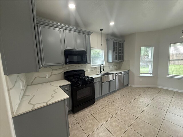 kitchen featuring a sink, backsplash, black appliances, gray cabinets, and light tile patterned floors